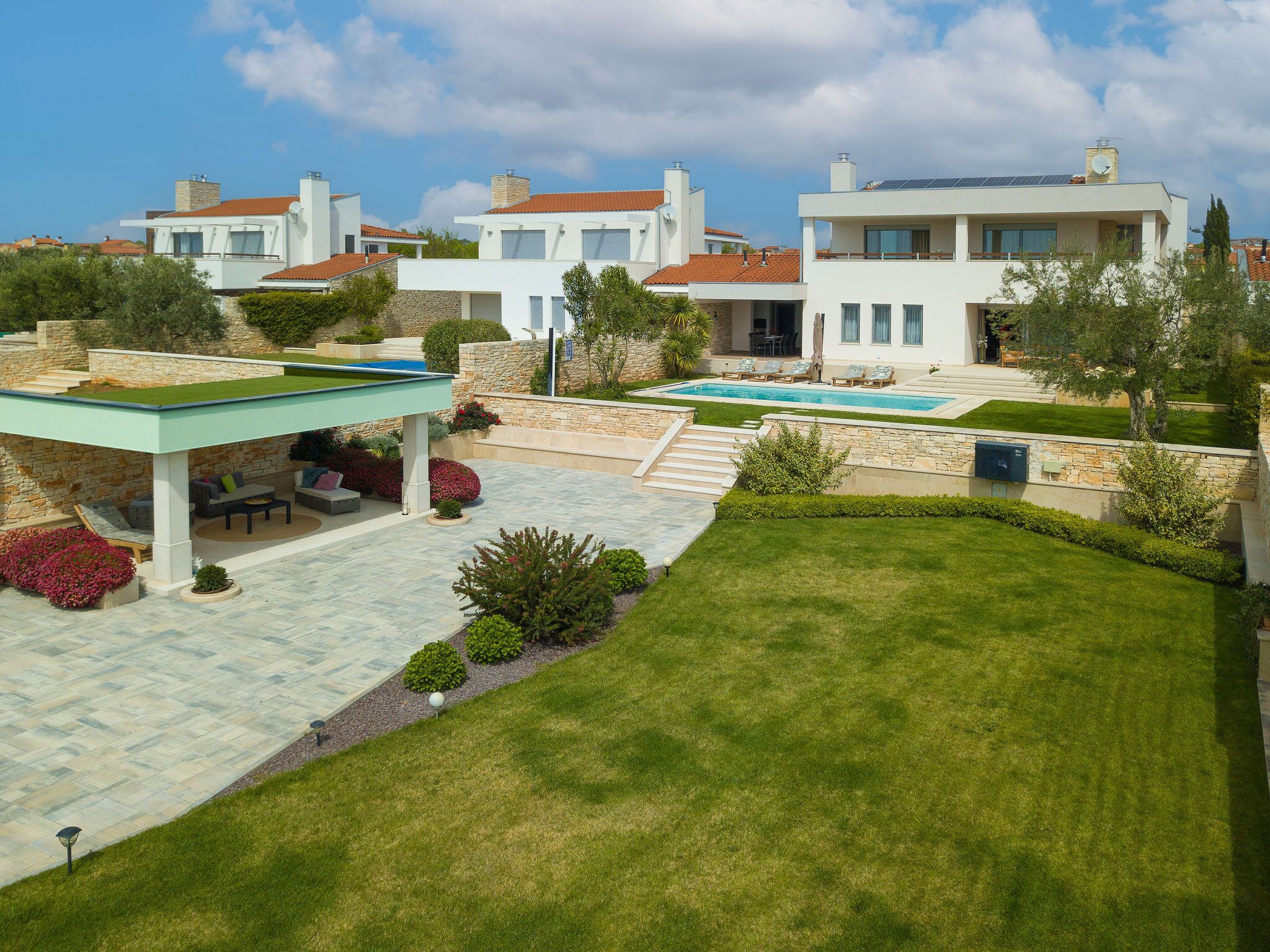 Une villa moderne dotée d’une piscine, d’un espace extérieur aménagé et d’un jardin bien entretenu.