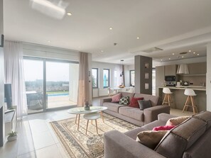 A modern living room with a sofa, a coffee table, and a view of the outdoors. - Villa Volimten by Interhome (Pula/Vodnjan)