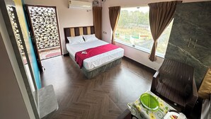 A hotel room with a bed, a wardrobe, a window with curtains, a ceiling fan, and an air conditioning unit. - OM LINGESWARAN Home Stay Tiruvannamalai (Tiruvannamalai)