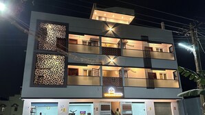 A multi-story building with a restaurant on the ground floor, balconies on each floor, and a sign indicating the name 'OM LINGESWARAN'. - OM LINGESWARAN Home Stay Tiruvannamalai (Tiruvannamalai)