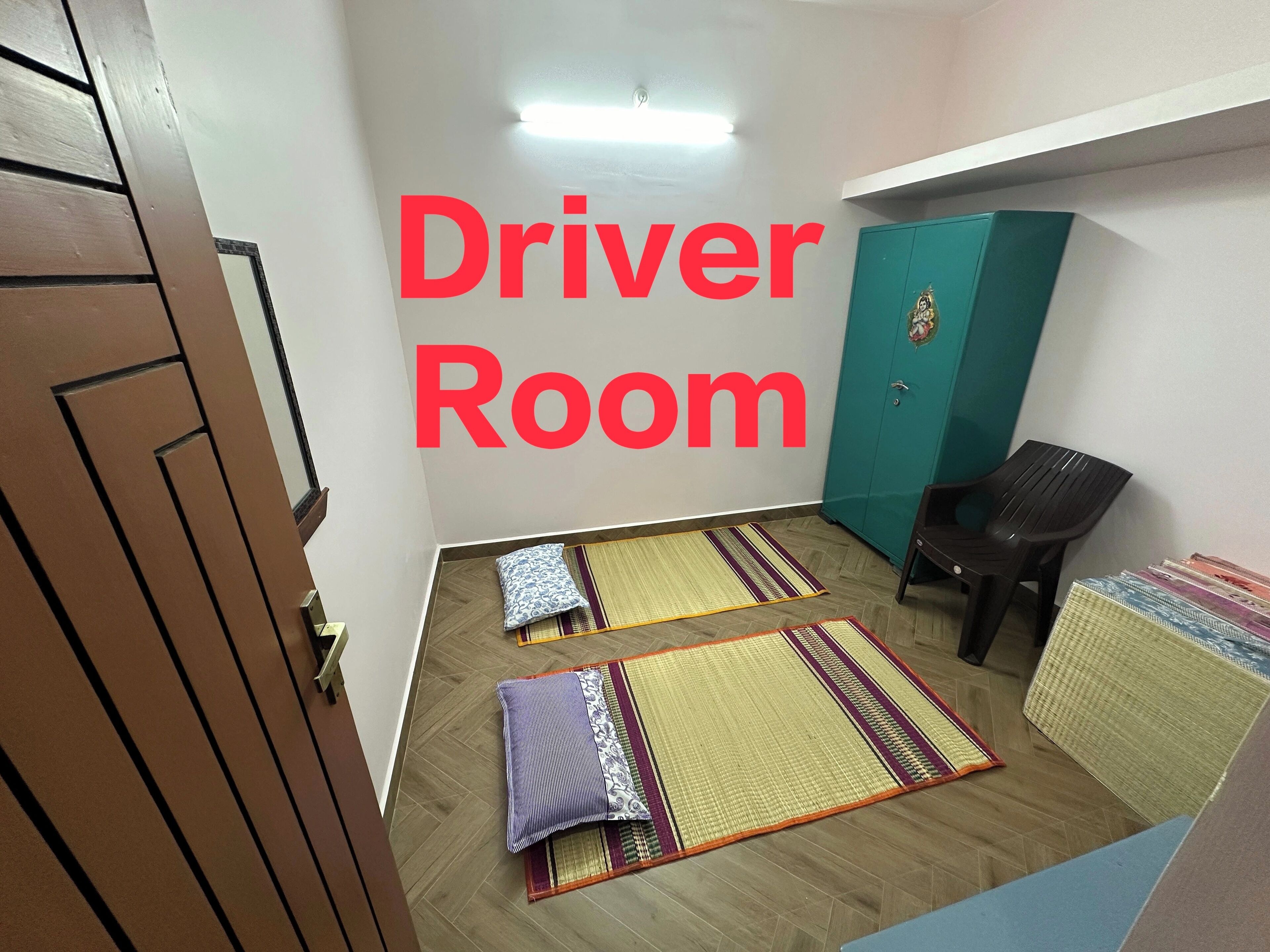 Una habitación con una puerta de madera, un mueble color turquesa y dos alfombras en el suelo.