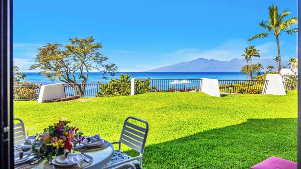 A dining area with a view of the ocean and mountains. - Napili Point | Oceanfront 4 BR, Sleeps 12 | Car Incl. w/ 6+ Nights | NAP ML-3604 by KBM (Lahaina)