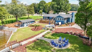 A residential property with a pond, a deck, and a fire pit area.