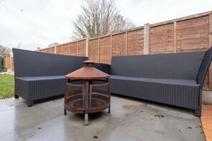 Un espace extérieur aménagé avec une table ronde et deux canapés.