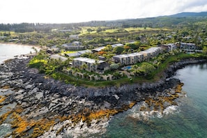 A coastal hotel with multiple buildings, a rocky shoreline, and clear water. - Napili Point | Oceanfront 8 BR, Sleeps 24 | Car Incl. w/ 6+ Nights | NAP ML-3619 by KBM (Lahaina)