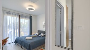 A bedroom with a bed, a large mirror, and a view of the outdoors through the window. - House Bronzin by Interhome (Rovinj/Kanfanar)