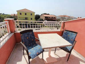A balcony with two chairs and a table, overlooking a residential area with houses. - Apartment 616 by Interhome (Rovinj)