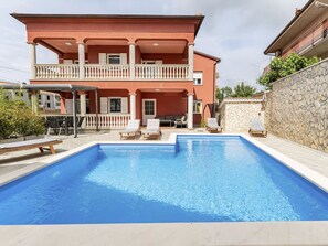 A two-story building with a swimming pool, outdoor seating, and a stone wall. - Apartment DP by Interhome (Bokordici)