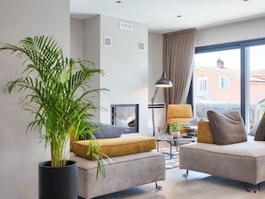 Un salon moderne avec un canapé, un fauteuil et une plante en pot.