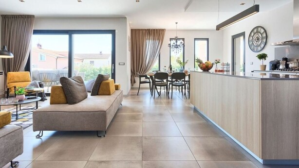 A modern living room with a sofa, dining area, and kitchen with a central island. - Villa Grande by Interhome (Poreč/Tar)