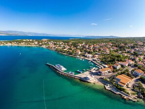 An aerial view of a coastal town with a marina, houses, and clear blue waters. - Apartment Tunera - 7 by Interhome (Krk/Šilo)
