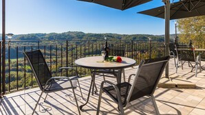 A terrace with a table, chairs, and a large umbrella. - House Horizon by Interhome (Pićan)