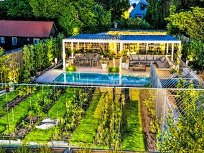 A rooftop garden with a pool, outdoor seating, and a covered patio area.