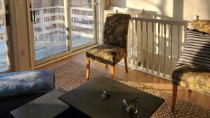 A room with a sliding glass door leading to a deck, a chair, a sofa, and a table with sunglasses and keys on it. - The Blue Dove (Shenandoah Farms)