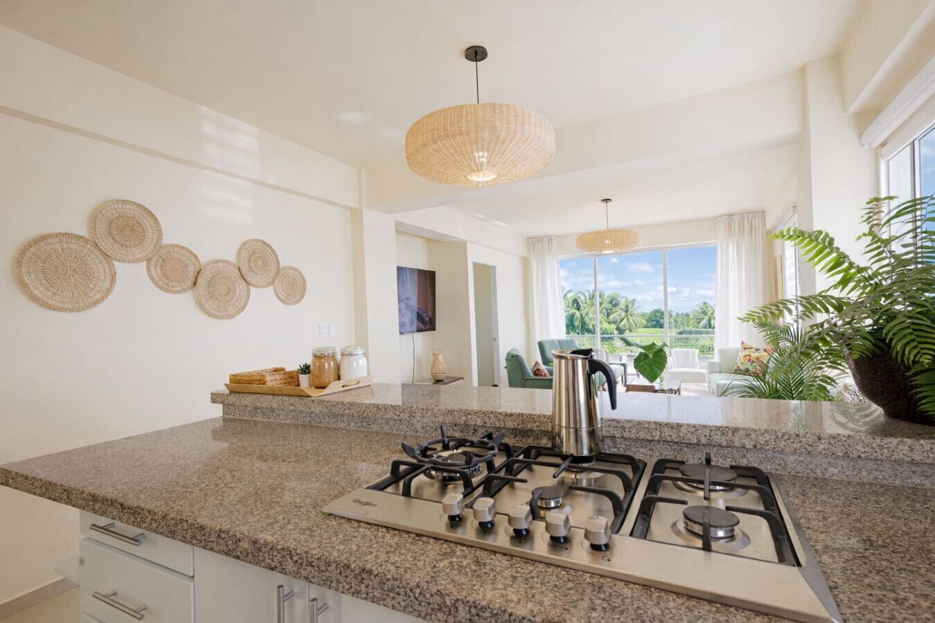 A modern kitchen with granite countertops, a gas stove, and a view of the outdoors.