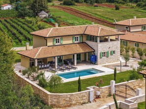 A two-story house with a swimming pool, surrounded by a stone wall and greenery. - Villa Lunistra by Interhome (Cere)