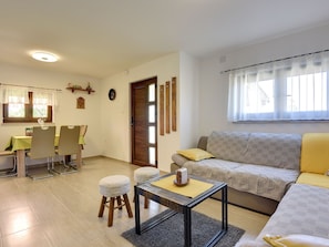 Ein Wohnzimmer mit einer Couch, einem Couchtisch und einem Essbereich mit Stühlen und einem Tisch.