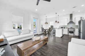 A modern living room with a sofa, coffee table, and dining area. - The Jasmine by Stay on 30a (Inlet Beach)