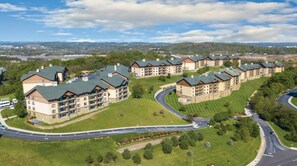 A multi-story hotel with a curved driveway, surrounded by well-maintained lawns and trees. - Spacious 2BR Smoky Mountains Condo - Sleeps 8 - Spring Break Weekend Getaway (Sevierville)