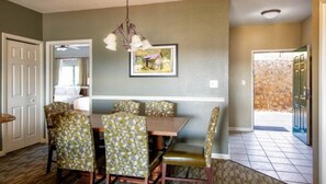 A dining area with a wooden table and chairs, a chandelier, and a framed picture on the wall. - Spacious 2BR Smoky Mountains Condo - Sleeps 8 - Spring Break Weekend Getaway (Sevierville)