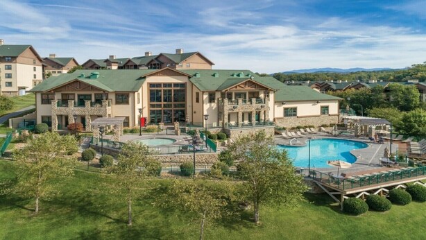A hotel with a large pool, multiple guest rooms, and a well-maintained lawn. - Spacious 2BR Smoky Mountains Condo - Sleeps 8 - Spring Break Weekend Getaway (Sevierville)