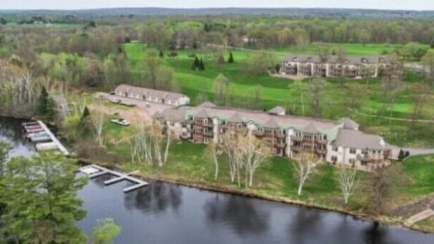 A large hotel complex with multiple buildings, a dock, and a lake.