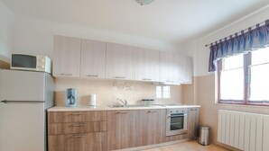A kitchen with a refrigerator, stove, and microwave. - Apartment Renato by Interhome (Rovinj/Kanfanar)