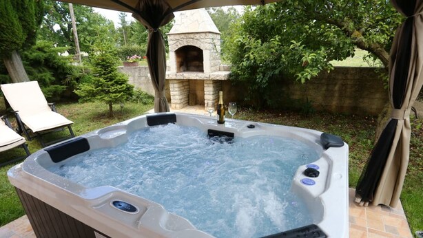 A hot tub with a stone structure in the background. - Apartment Renato by Interhome (Rovinj/Kanfanar)