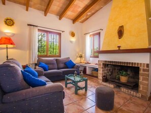 Ein gemütliches Wohnzimmer mit Kamin, einer Sofagarnitur und einem Couchtisch.