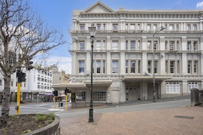 Ein historisches Gebäude mit einer klassischen Fassade, großen Fenstern und einem markanten Eingang.