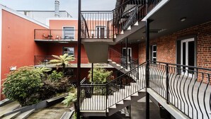 A multi-level residential building with balconies, a central staircase, and a small garden area. - Manor Place Stays Apartment one (Dunedin)