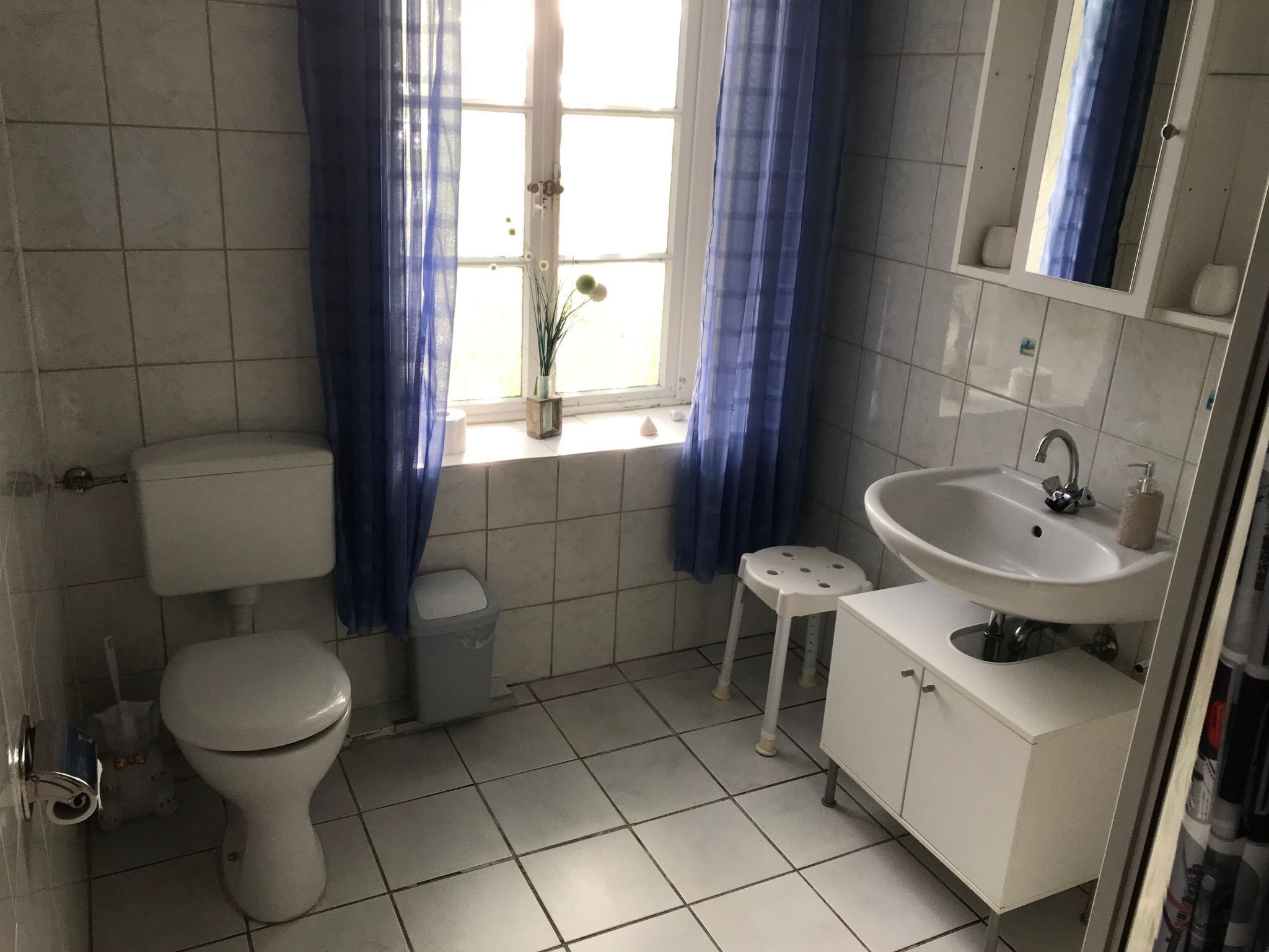 Ein kleines Badezimmer mit Toilette, Waschbecken und Fenster.