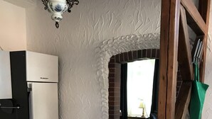 Eine Küche mit weißen Schränken, einem Kühlschrank und Holzboden.