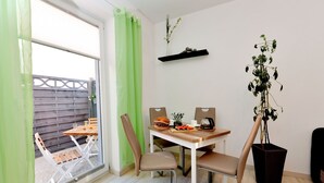 A dining area with a table, chairs, and a potted plant. - Moderne Wohnungen in historischem Ambiente unweit zur Altstadt und zum Hafen by Interhome (Stralsund)