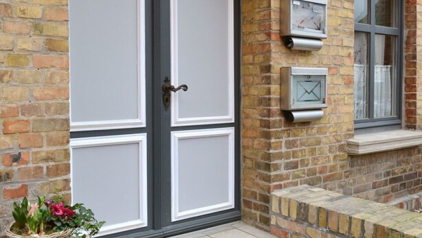 A brick building with a double door, a mailbox, and a window with a curtain. - Moderne Wohnungen in historischem Ambiente unweit zur Altstadt und zum Hafen by Interhome (Stralsund)