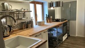 A modern kitchen with a wooden countertop, stainless steel appliances, and a built-in oven. - Kräuterhof-Ferienwohnung by Interhome (Missen-Wilhams)