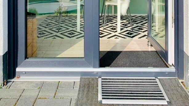 Un intérieur moderne avec une porte vitrée donnant sur un balcon.