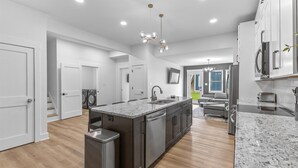 Una cocina moderna con una isla central, electrodomésticos de acero inoxidable y encimera de mármol.