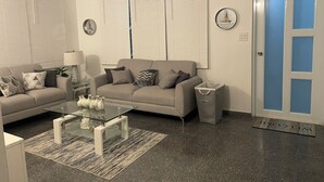 A modern living room with two sofas, a glass coffee table, and a small side table. - Palmas y Brisas – Comfortable 2-Bedroom Home Near the Beach (Barceloneta)