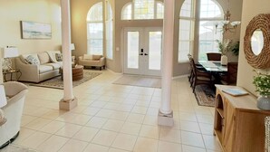 A spacious living room with high ceilings, large windows, and a dining area. - Luxury Waterfront Home-Heated Pool-Dock-Sleeps 10 (Cape Coral)