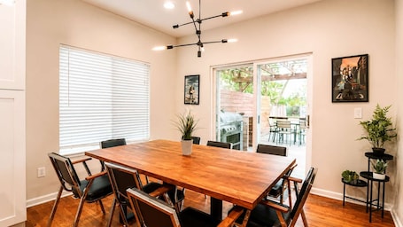A dining area with a wooden table, chairs, and a potted plant.
