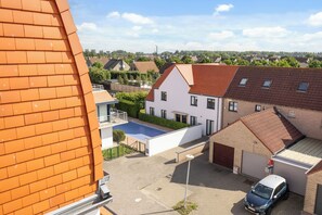 Un quartier résidentiel avec des maisons, une piscine et une voiture garée dans l’allée.