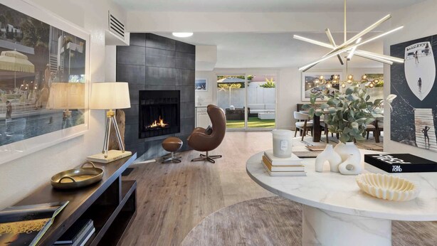 Una sala de estar moderna con chimenea, comedor y vistas al exterior.