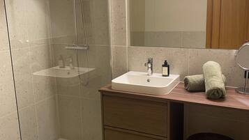 Een haardroger, handdoeken, zeep, toiletpapier