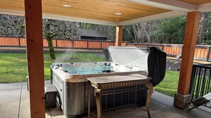 Un bain à remous avec une table dans un espace extérieur abrité.