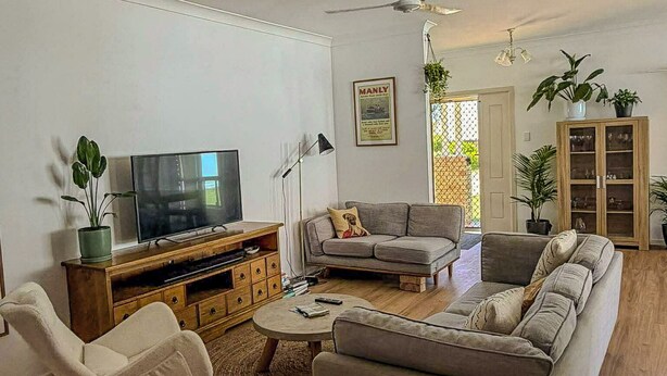 A living room with a TV, sofas, a rocking chair, and a cabinet. - Your Pet Friendly Home Away From Home In Yeppoon | Sleeps 10 (Yeppoon)