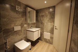 A modern bathroom with a marble wall, a white sink, and a toilet. - Duplex City 01 in Durr s (Durrës)
