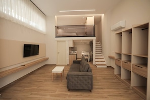 A modern apartment with a living room, a dining area, a kitchen, and a staircase leading to a loft. - Duplex City 08 in Durr s (Durrës)