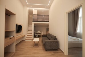 A modern apartment with a loft bedroom, a dining area, and a living room with a sofa and a TV. - Duplex City 05 in Durr s (Durrës)