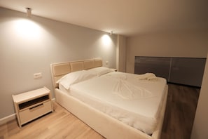 Ein modernes Schlafzimmer mit einem großen Bett, Nachttischen und einem Einbauschrank.